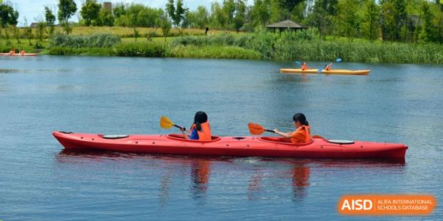 Students kayaking or canoeing on a lake during an outdoor education trip at Yew Chung International School of Beijing.