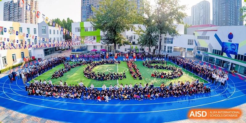 A large group of students on a field forming a human shape or letter during an event at Yew Chung International School of Beijing.