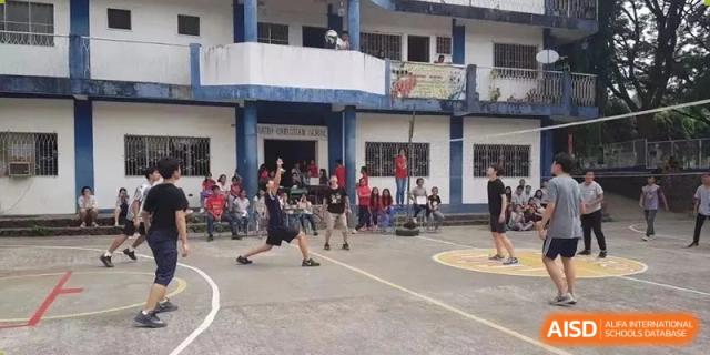 Students playing a team sport on an outdoor court with spectators in the background at Yew Chung International School of Beijing.