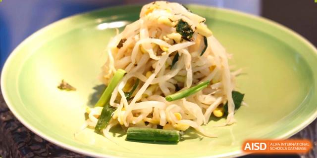 A serving of stir-fried bean sprouts and scallions, likely a Chinese or Korean dish, served at Yew Chung International School of Beijing.