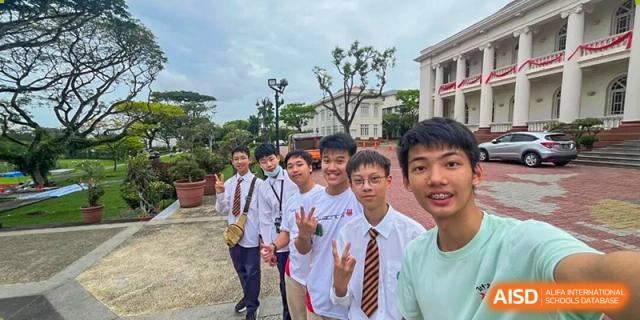 A group of male students in school uniforms posing outdoors on the campus of Wuxi Big Bridge Academy.