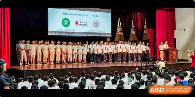 Students lined up on stage receiving recognition during a formal ceremony or assembly at Wuxi Big Bridge Academy.