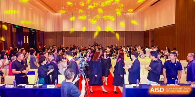 Graduates from Zhuhai Oriental Yinghua International Academy gathered on a red carpet at a ceremony.