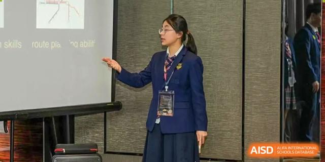 A female student from Zhuhai Oriental Yinghua International Academy speaking or presenting while wearing her school uniform.
