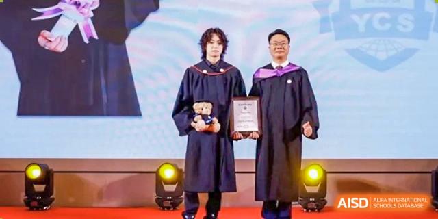 A graduate from Zhuhai Oriental Yinghua International Academy standing with two faculty members while receiving an award.