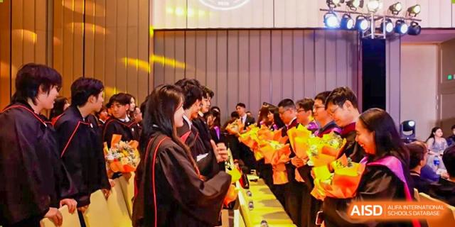 Students from Zhuhai Oriental Yinghua International Academy interacting with others at a busy event booth.