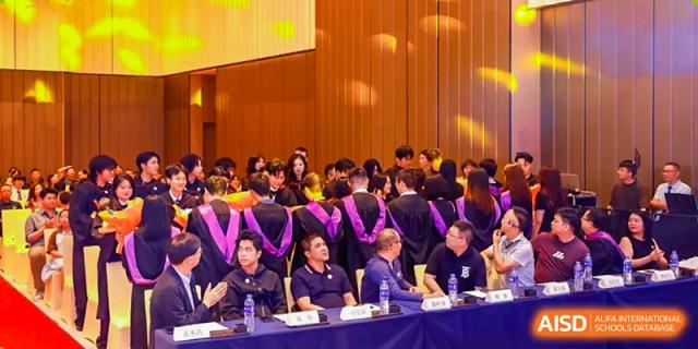 Students from Zhuhai Oriental Yinghua International Academy seated at tables in a large event hall during a ceremony or lecture.
