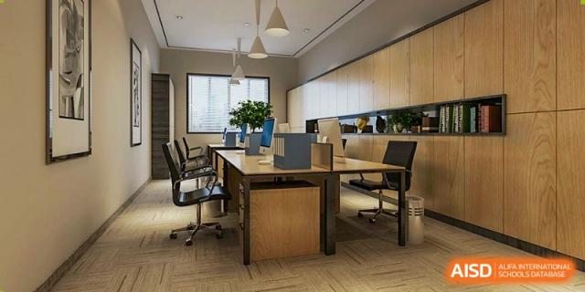 An interior view of a modern, well-lit office or study area with large desks, chairs, and natural light, used by staff or students at Changjun Bilingual School Of Changsha City.