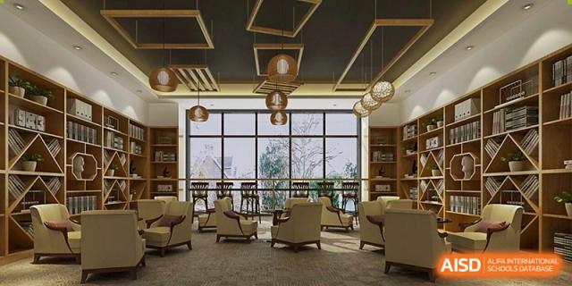 A cozy, modern lounge at Changjun Bilingual School Of Changsha City, featuring plush chairs, low tables, bookshelves, and large windows overlooking a bright courtyard.