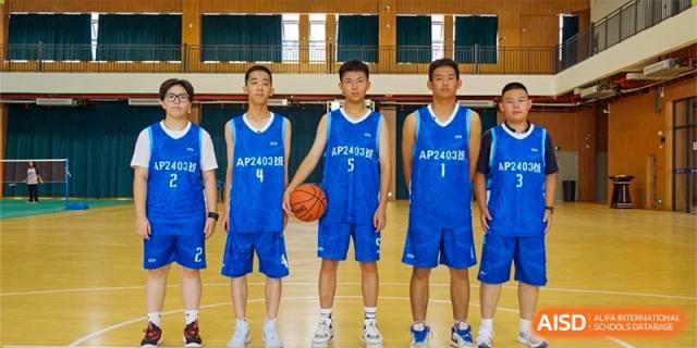Four students from Changjun Bilingual School Of Changsha City's basketball team posing in blue jerseys.