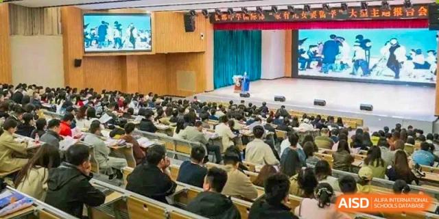 Wide view of students at Changjun Bilingual School Of Changsha Cityseated in a large, full lecture hall or assembly auditorium.