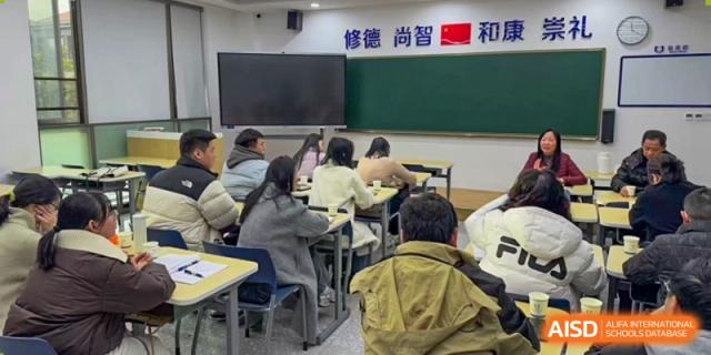 Students attending a class or lecture with a blackboard and projection screen in a classroom at Cogdel Cranleigh High School.