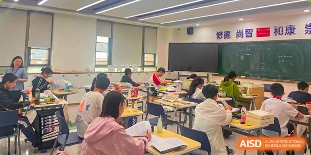 A group of students from Cogdel Cranleigh High School seated at desks and focused on their work during a classroom session.