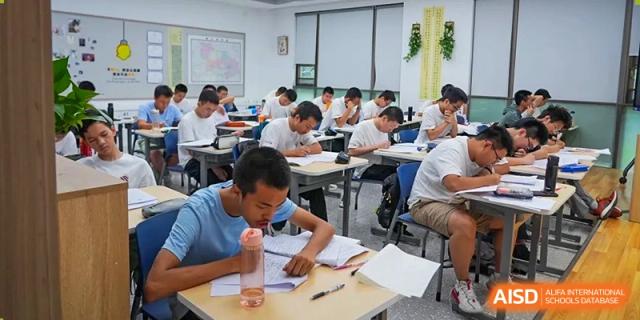 A male student from Cogdel Cranleigh High School looking intently at his work while sitting at a desk during a class.