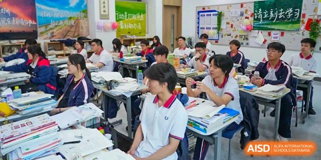Students from Cogdel Cranleigh High School, some in uniforms, seated at desks and participating in a class or group activity.