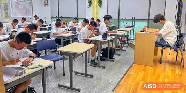 Students from Cogdel Cranleigh High School working individually at their desks in a classroom with large windows providing natural light.