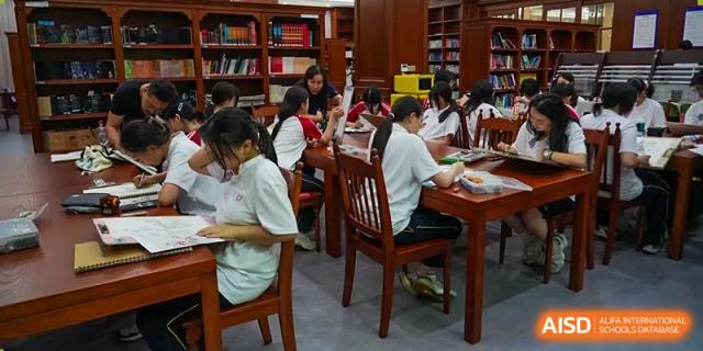 Students from Cogdel Cranleigh High School eating a meal together in a dining hall or cafeteria.