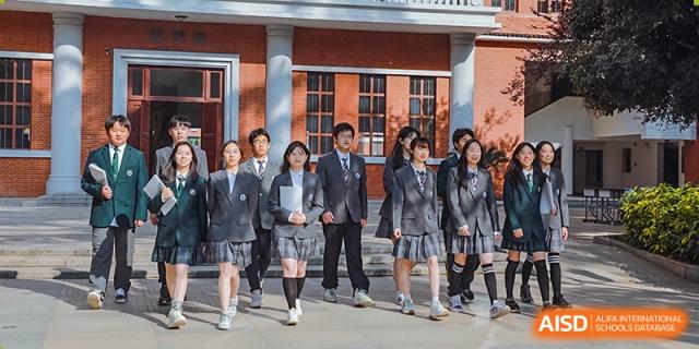 A group of students and a male teacher from Cogdel Cranleigh High School walking outdoors, all dressed in school uniforms.