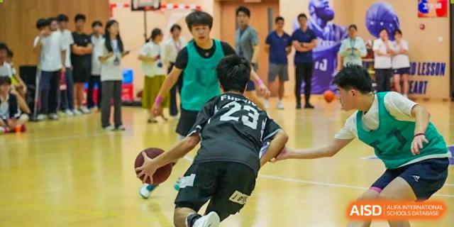 Cogdel Cranleigh High School student wearing a black jersey with number 23 dribbling a basketball aggressively during a game.