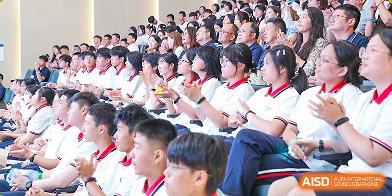 Students of Cogdel Cranleigh High School sitting and applauding during a school event in an auditorium.