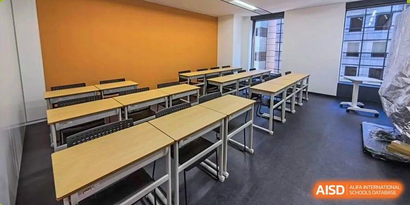 An empty classroom with rows of desks and chairs at Cogdel Cranleigh High School.