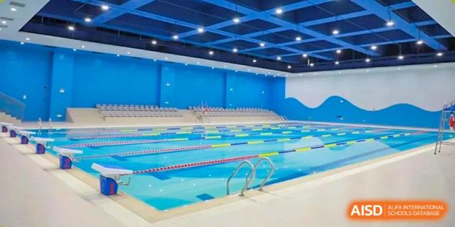 Wide interior view of the large, modern indoor swimming and diving pool at Cogdel Cranleigh High School.