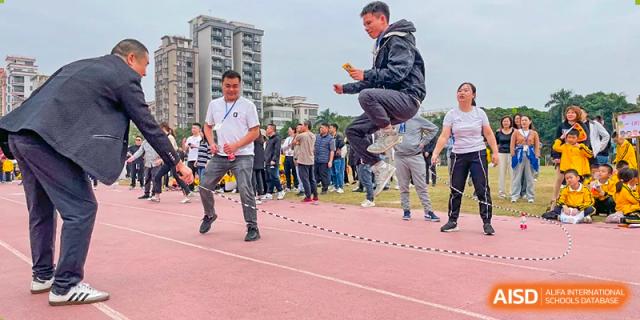 A male student from Humen Foreign Language School International Division leaps high in the air while jump-roping on a track during a school event.