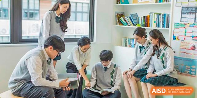 Maple Glory Education students reading and studying together in a brightly lit room with white bookshelves.