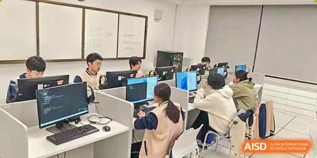 Students from Maple Glory Education working on computers in a dedicated computer lab or classroom.