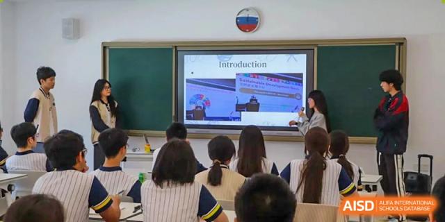 A classroom of Maple Glory Education students watching an 'Introduction' presentation on a large screen.