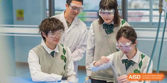 A group of Maple Glory Education students and a teacher in lab coats and safety goggles performing a scientific experiment.