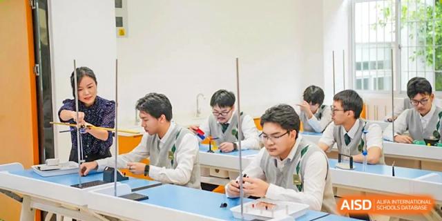 Male students from Maple Glory Education engaged in a hands-on activity or experiment at blue tables.