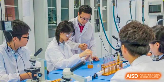 Two students from Maple Glory Education wearing white lab coats, conducting a chemistry experiment with beakers and test tubes.