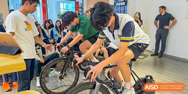 Two male students from Maple Glory Education participating in a stationary indoor cycling or spinning class.