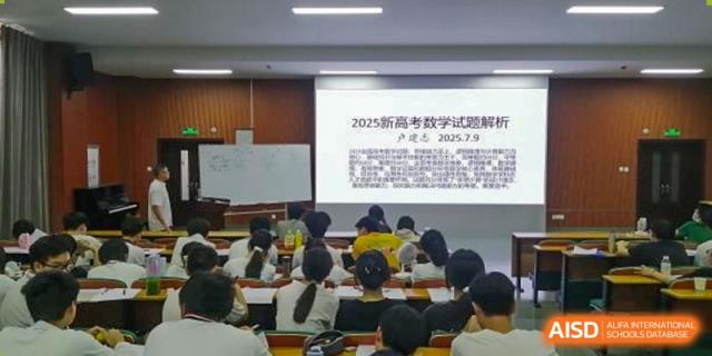 A large group of students taking an examination or attending a lecture in a classroom, with a projected document on the screen, at Maple Leaf International School Wuhan.