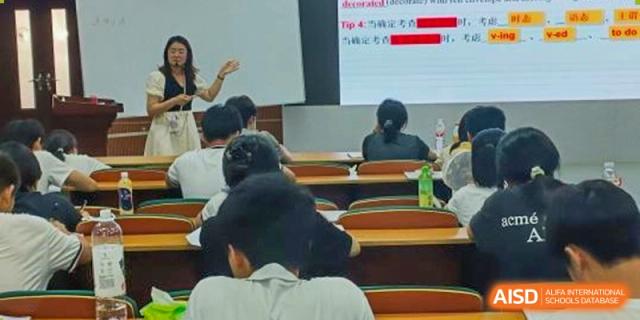 Students sitting in a classroom while a teacher points to a presentation on the screen during a lesson at Maple Leaf International School Wuhan.