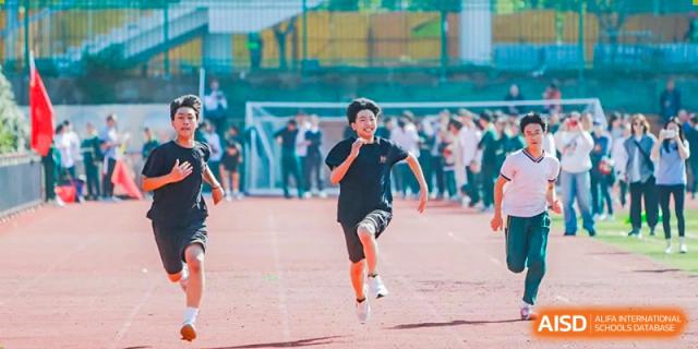 A young student in black running fast on an outdoor track field during a sports competition at Maple Leaf International School Wuhan.
