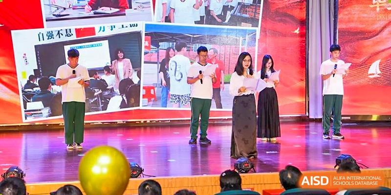 Two male and two female adults standing on a stage, possibly hosting an event or acting as judges, at Maple Leaf International School Wuhan.