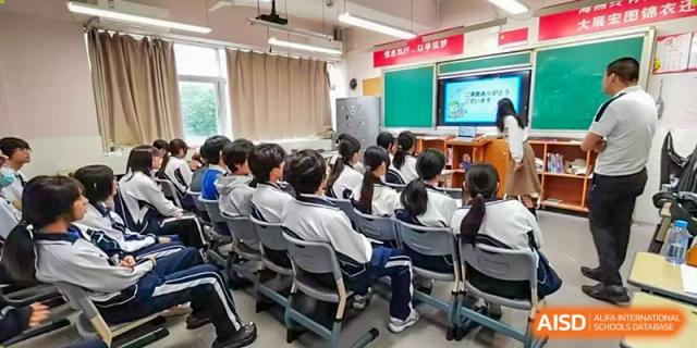 A class of students in uniform seated at their desks, attentively facing the front of the classroom at Oxstand International School, Shenzhen.