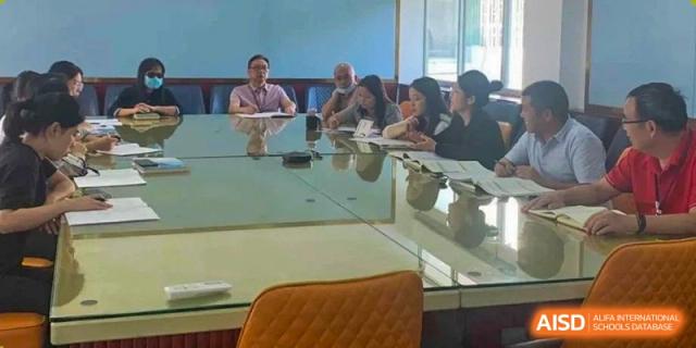 Students seated around a large table, possibly for a meeting or group study session, at Oxstand International School, Shenzhen.