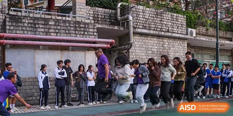 A group of students and adults running outside a building during a school activity or event at Oxstand International School, Shenzhen.