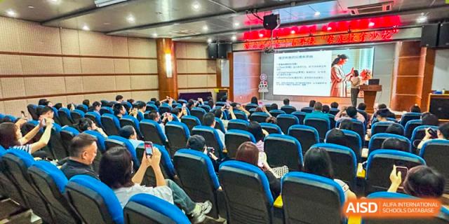 An auditorium filled with seated students watching a presentation on a large screen at Oxstand International School, Shenzhen.