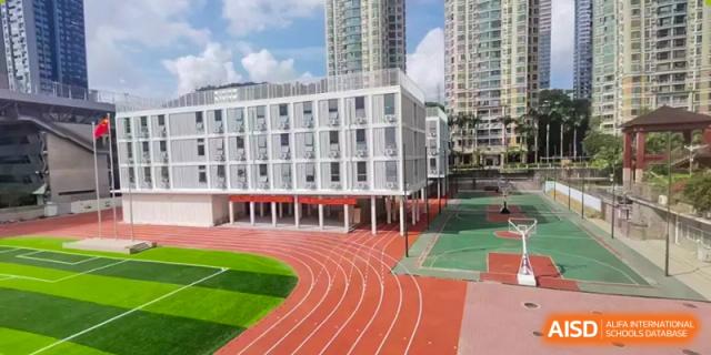The modern school building next to a red running track and green sports field at Oxstand International School, Shenzhen.