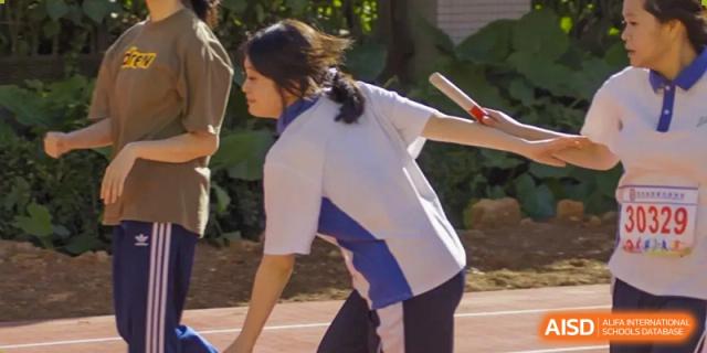 A female student throwing a javelin or baton during an athletics event at Oxstand International School, Shenzhen.