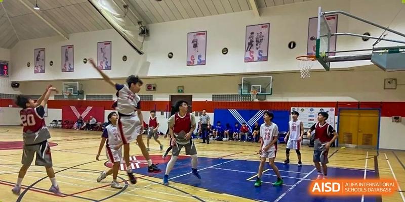 A basketball game taking place in an indoor gym at Shanghai Livingston American School.