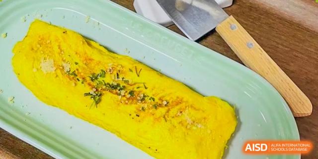 A savory egg omelet garnished with herbs on a plate, a healthy meal choice available at Shanghai Livingston American School.