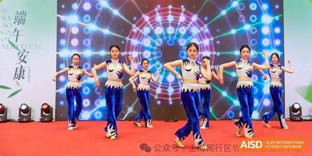Shanghai United International School (SUIS-Jiaoke) Jiaoke Campus students performing an energetic dance routine on a stage with a brightly lit, colorful background.