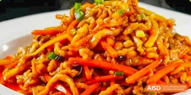 A close-up of a dish featuring stir-fried noodles with shredded vegetables and red peppers, representing HEALTH & NUTRITION at Shanghai United International School (SUIS-Jiaoke) Jiaoke Campus.
