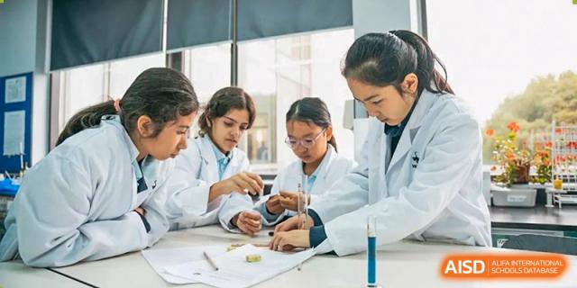 Three students wearing lab coats performing a science experiment under the supervision of a teacher in a lab at Western International School of Shanghai.