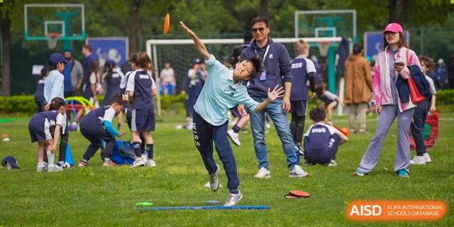 A student mid-swing during an outdoor sports activity on the grass field at Western International School of Shanghai.